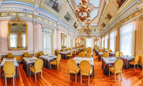 a dining room with tables and chairs and a chandelier at Blau Gran Hotel Las Caldas - Adults Only in Las Caldas