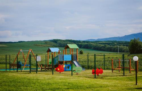 a playground with colorful equipment in a field at Biała Akacja Resort & Business in Prudnik