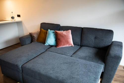 a blue couch with pillows on it in a living room at Zonnig centraal gelegen app. Nieuwpoort-bad op 80m van de zee in Nieuwpoort