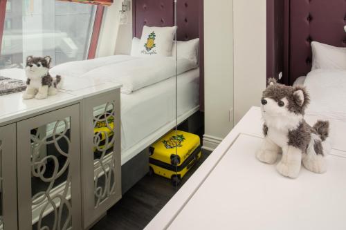 a cat sitting on top of a bed next to a window at Staypineapple, An Artful Hotel, Midtown New York in New York