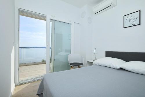 - une chambre avec un lit et une vue sur l'océan dans l'établissement Kona, à Tkon