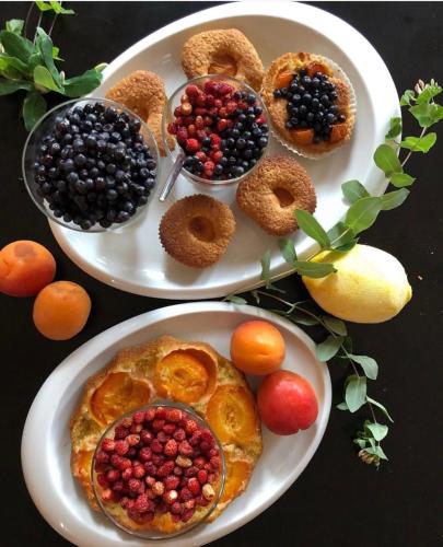 two plates of food on a table with fruit at Padam Hotel & SPA in Ulcinj