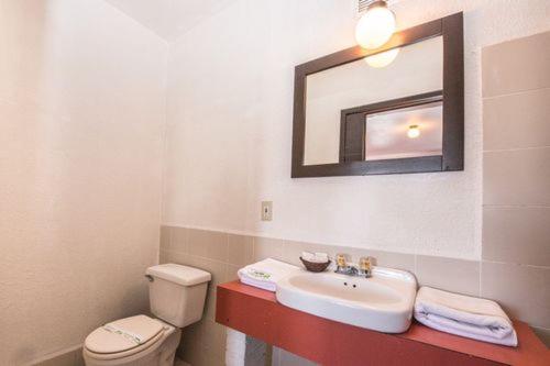 a bathroom with a sink and a toilet and a mirror at Hotel Descanso Inn in Tijuana