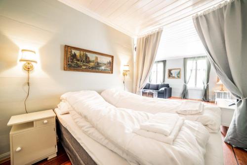 a white room with a large white bed in it at Lærdalsøren Motor Guesthouse in Lærdalsøyri