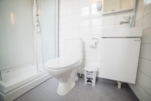 a white bathroom with a toilet and a sink at Lærdalsøren Motor Guesthouse in Lærdalsøyri