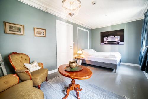a room with a bed and a table and a chair at Lærdalsøren Motor Guesthouse in Lærdalsøyri
