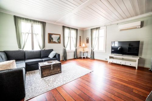 a living room with a couch and a flat screen tv at Lærdalsøren Motor Guesthouse in Lærdalsøyri