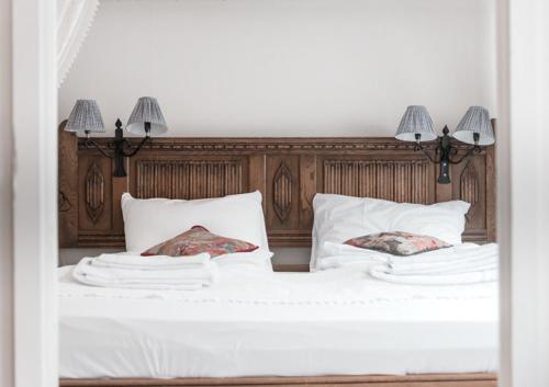 a bed with white sheets and two pillows on it at Lærdalsøren Motor Guesthouse in Lærdalsøyri