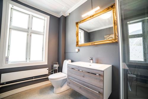 a bathroom with a sink and a toilet and a mirror at Lærdalsøren Motor Guesthouse in Lærdalsøyri