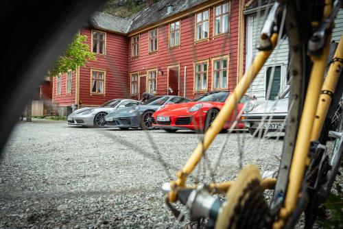 a row of cars parked in front of a red building at Lærdalsøren Motor Guesthouse in Lærdalsøyri