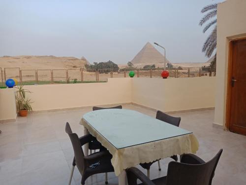uma mesa e cadeiras com vista para as pirâmides em shahbor 2pyramids view no Cairo