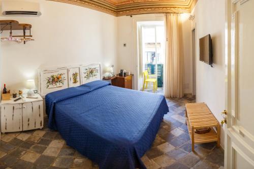 - une chambre avec un lit doté d'un couvre-lit bleu dans l'établissement Casa don Luigi, à Cefalù