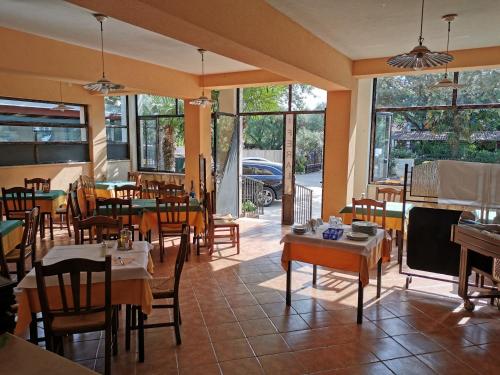 un restaurante vacío con mesas, sillas y ventanas en Rooms and Apartment Feral, en Rovinj