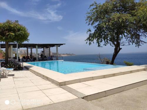a swimming pool with a view of the ocean at Union Amicale Corse Dakar in Dakar