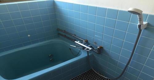 Tanabe - Hotel / Vacation STAY 15383 في تانابا: حوض استحمام أزرق في حمام من البلاط الأزرق