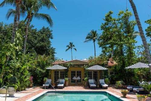 a villa with a swimming pool and palm trees at Hotel Escalante in Naples