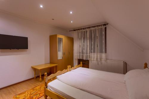 a bedroom with two beds and a flat screen tv at Vila Slavica in Zlatibor