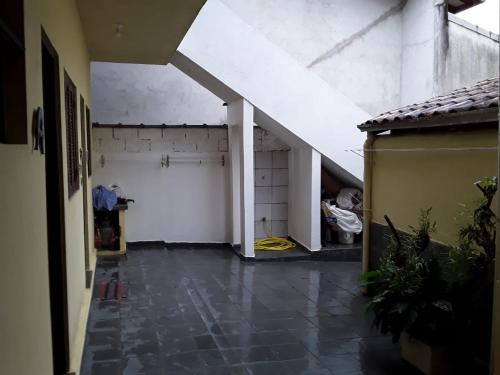 an empty room with a white wall and a garage at Casa Temporada Ubatuba in Ubatuba
