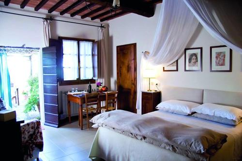 um quarto com uma cama, uma secretária e uma janela em Le Traverse em Pienza