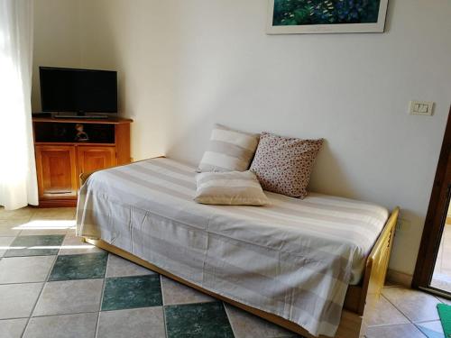 uma cama com almofadas num quarto em Casa Leoni Capoliveri Isola d'Elba em Capoliveri