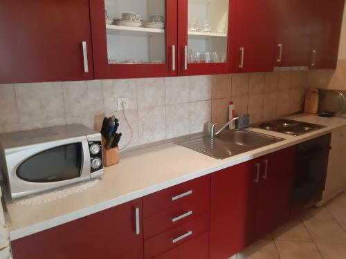 uma cozinha com um micro-ondas e um lavatório em Jelaska Apartment em Marina