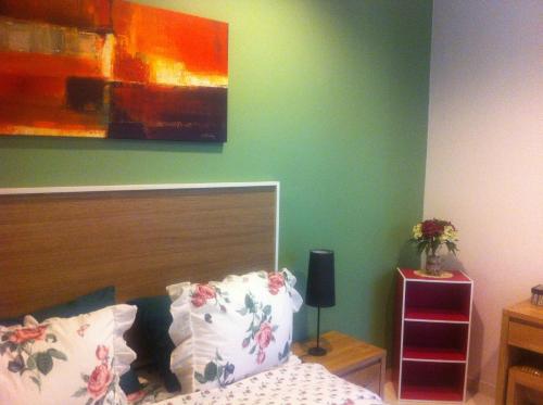 a bedroom with a bed and a painting on the wall at Panca Dewi Guest House in Yogyakarta