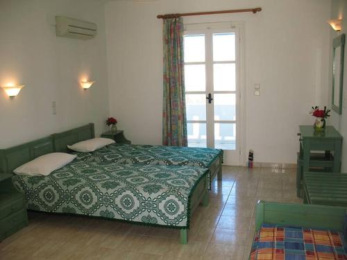 聖安娜納克索斯的住宿－HOTEL KAPARI，一间卧室设有两张床和大窗户