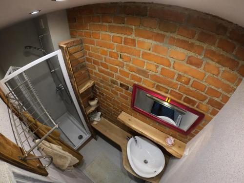 an overhead view of a bathroom with a brick wall at Apartament w Kamienicy in Biskupiec