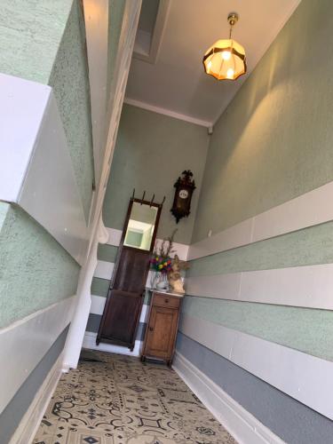 a hallway with striped walls and a stair case at Apartament w Kamienicy in Biskupiec