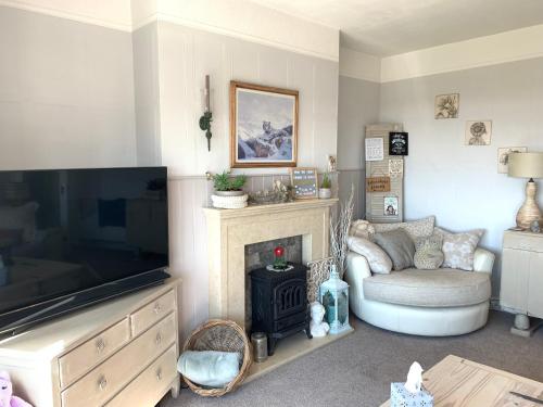 a living room with a television and a fireplace at HomeStay In The Bay With Sea Views in Heysham