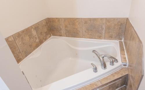 a sink with two faucets in a bathroom at Canadas Best Value Inn & Suites Summerside in Summerside