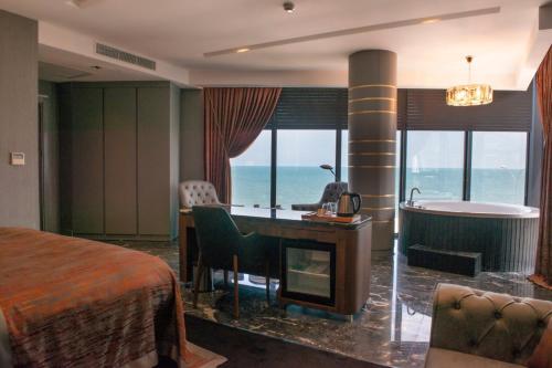 B&C HOTEL في أتاكوم: غرفة في الفندق بها سرير ومكتب وحوض استحمام