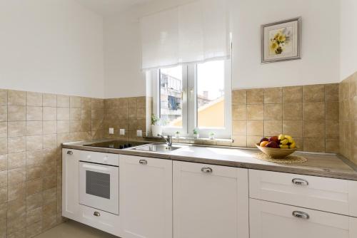 a kitchen with a sink and a bowl of fruit at LRS Apartment in the center of Zadar in Zadar