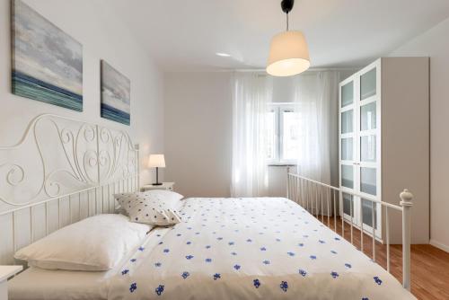 a white bedroom with a large bed with a white bedspread at LRS Apartment in the center of Zadar in Zadar