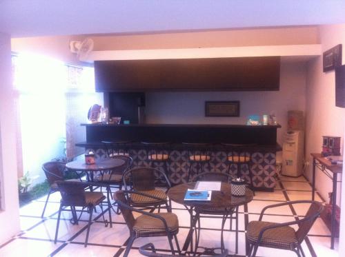 a room with tables and chairs and a piano at Panca Dewi Guest House in Yogyakarta