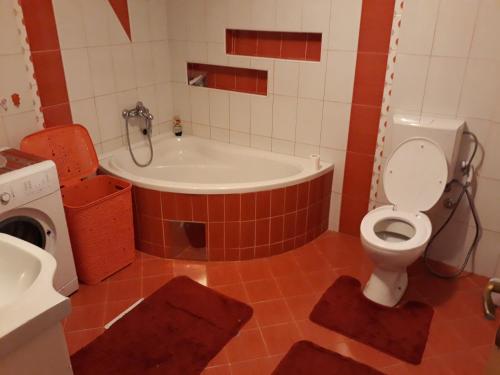 a bathroom with a tub and a toilet and a sink at Apartment AMRA in Tuzla