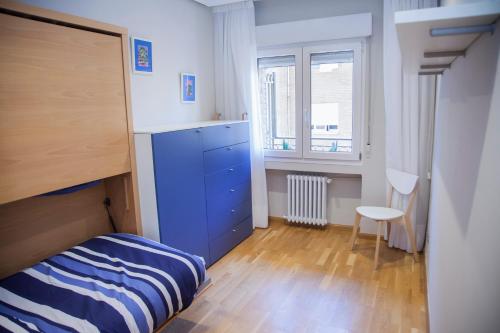 um pequeno quarto com uma cómoda azul e uma cama em Apartamento 8 - 10 pax Soria - Centro em Soria