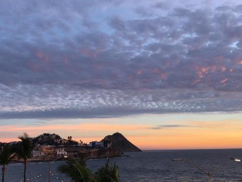 a view of an island in the ocean at sunset at Zona Dorada Mazatlan in Mazatlán