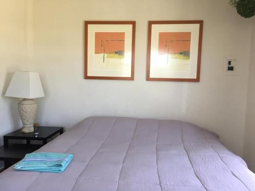 a bed in a bedroom with two pictures on the wall at Zona Dorada Mazatlan in Mazatlán