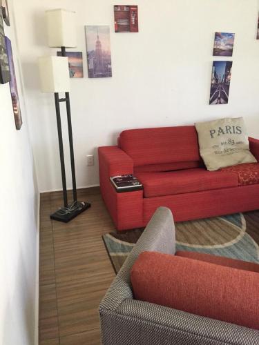 a living room with a red couch and a lamp at Zona Dorada Mazatlan in Mazatlán