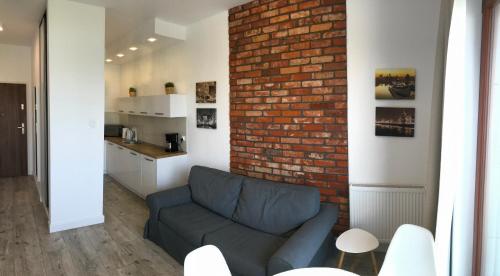 salon z kanapą i ceglaną ścianą w obiekcie Nowa Motława Studio 31 SPA w Gdańsku