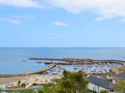 a beach with a bunch of boats in the water at Burton House Apartment in Lyme Regis