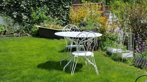 a table and two chairs in a garden at Les Iris Chambres d’hôte in Niedermorschwihr