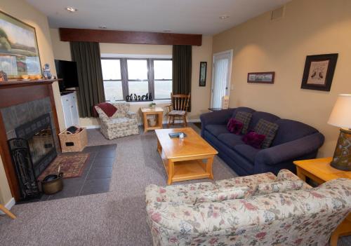 a living room with a couch and a fireplace at Winterplace on Okemo Mountain in Ludlow