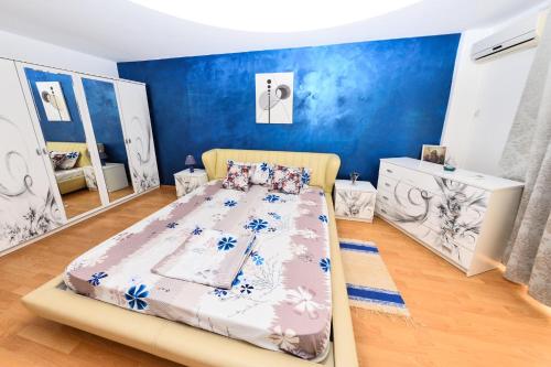 1 dormitorio con 1 cama con pared azul en Apartament Florin, en Mamaia