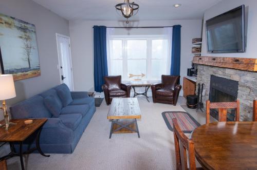 a living room with a blue couch and a fireplace at Winterplace on Okemo Mountain in Ludlow