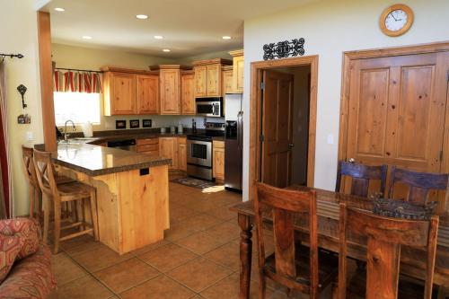 a kitchen with wooden cabinets and a table with chairs at Zion Ponderosa Ranch Resort in Springdale