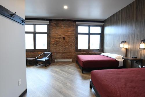 a bedroom with two beds and a brick wall at Crosby Lofts in Crosby
