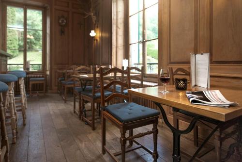 a room with tables and chairs and a glass of wine at Au Vieux Manoir in Monthey