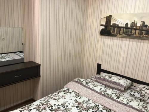 a bedroom with a bed and a dresser at Comfort Arenda.Minsk 2 in Minsk